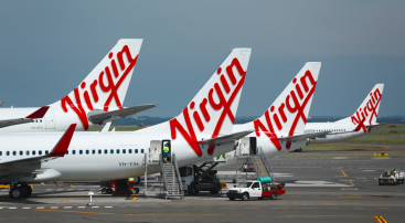 Photo of 4 aeroplane tail fins and rudders showing Virgin Australia branding.